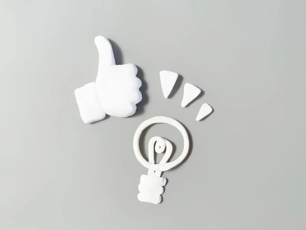 親指を立てた手と電球のマーク