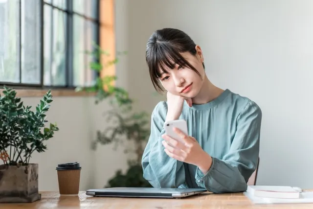 椅子に座りスマホを見ている女性