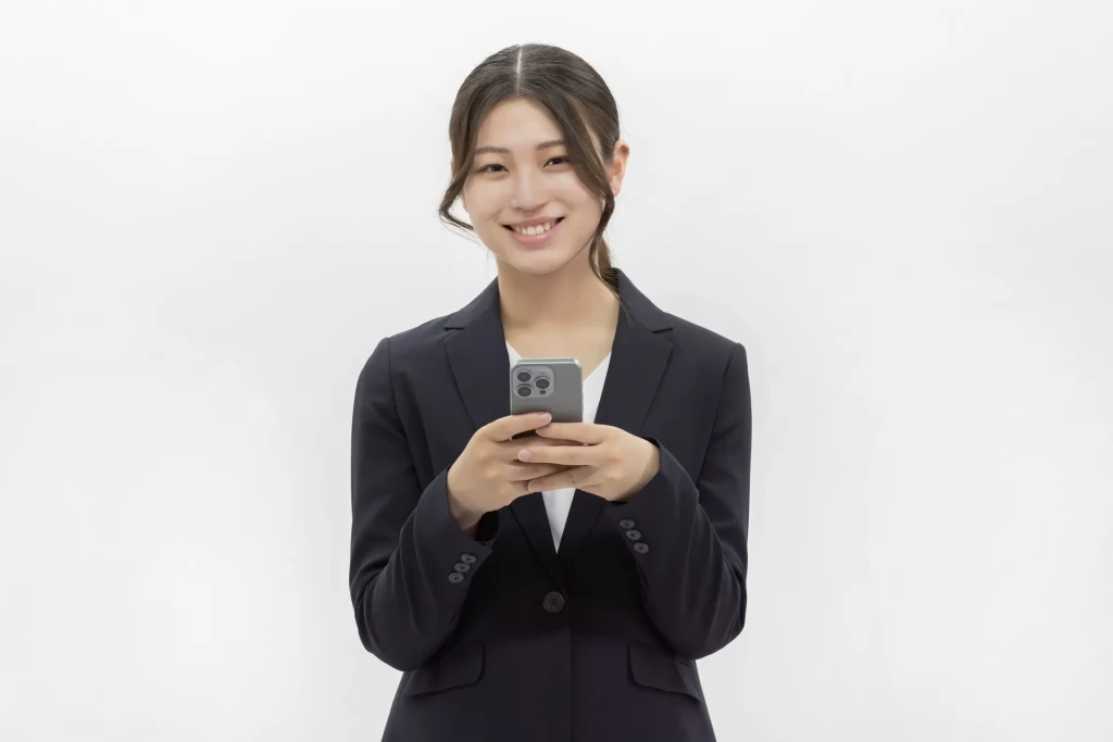 スマホを両手に持っている女性