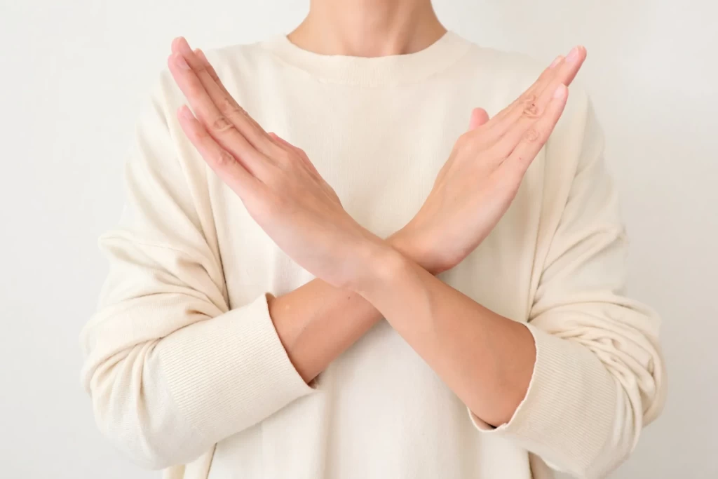 手でバツを作っている女性