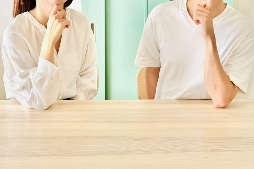 椅子に座って顎に手をあてて考える男女