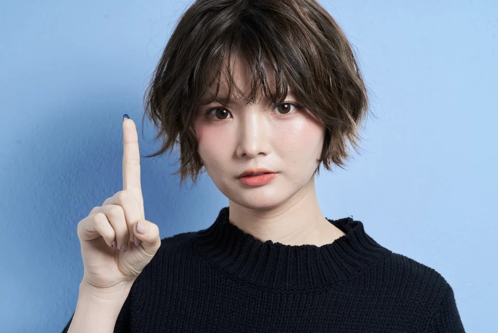 人差し指を立てる女性