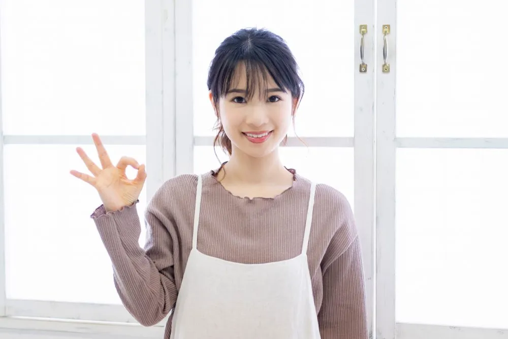 女性が右手で丸マークを作っている