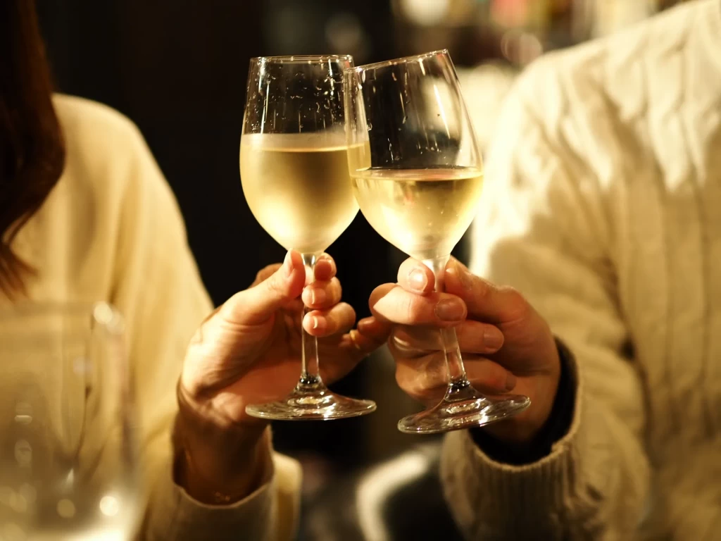 ワイングラスで乾杯する男女の手元