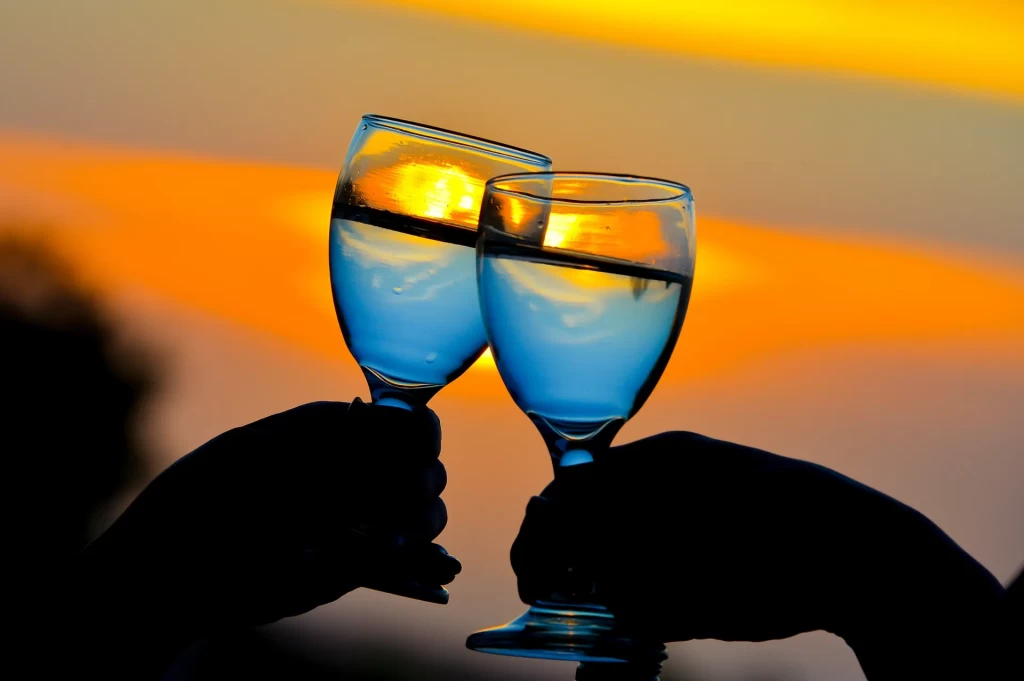 夕焼けを背景に、グラスを合わせる二人