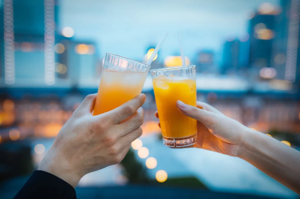ジュースで乾杯する男女の手