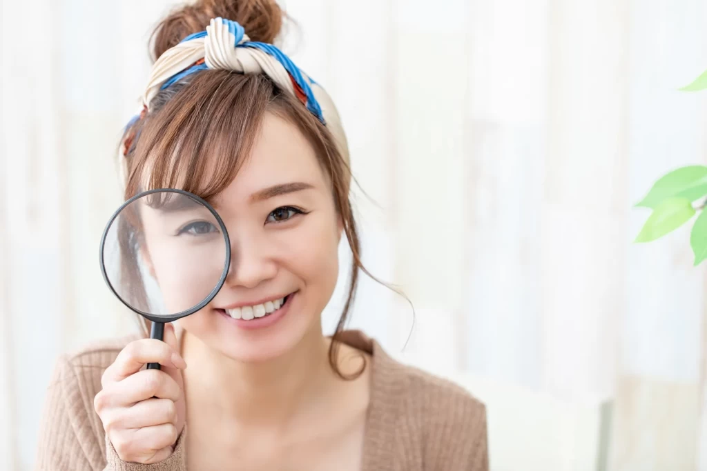 虫眼鏡越しに見つめてくるお団子ヘアの女性