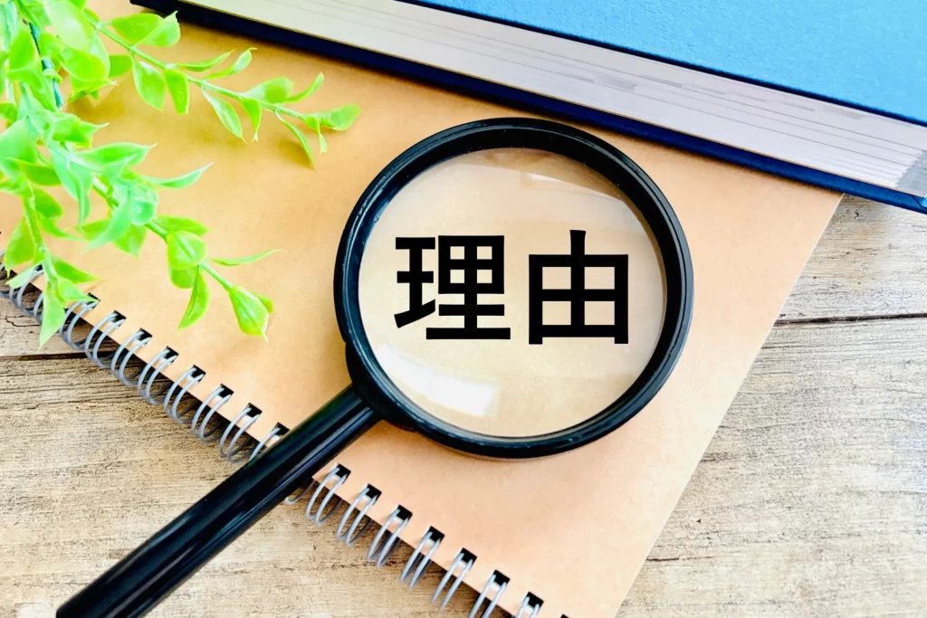 虫眼鏡で見る「理由」の文字とノート